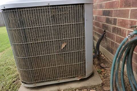 Outdoor condenser unit with the fin surface matted with lawn clippings and dust